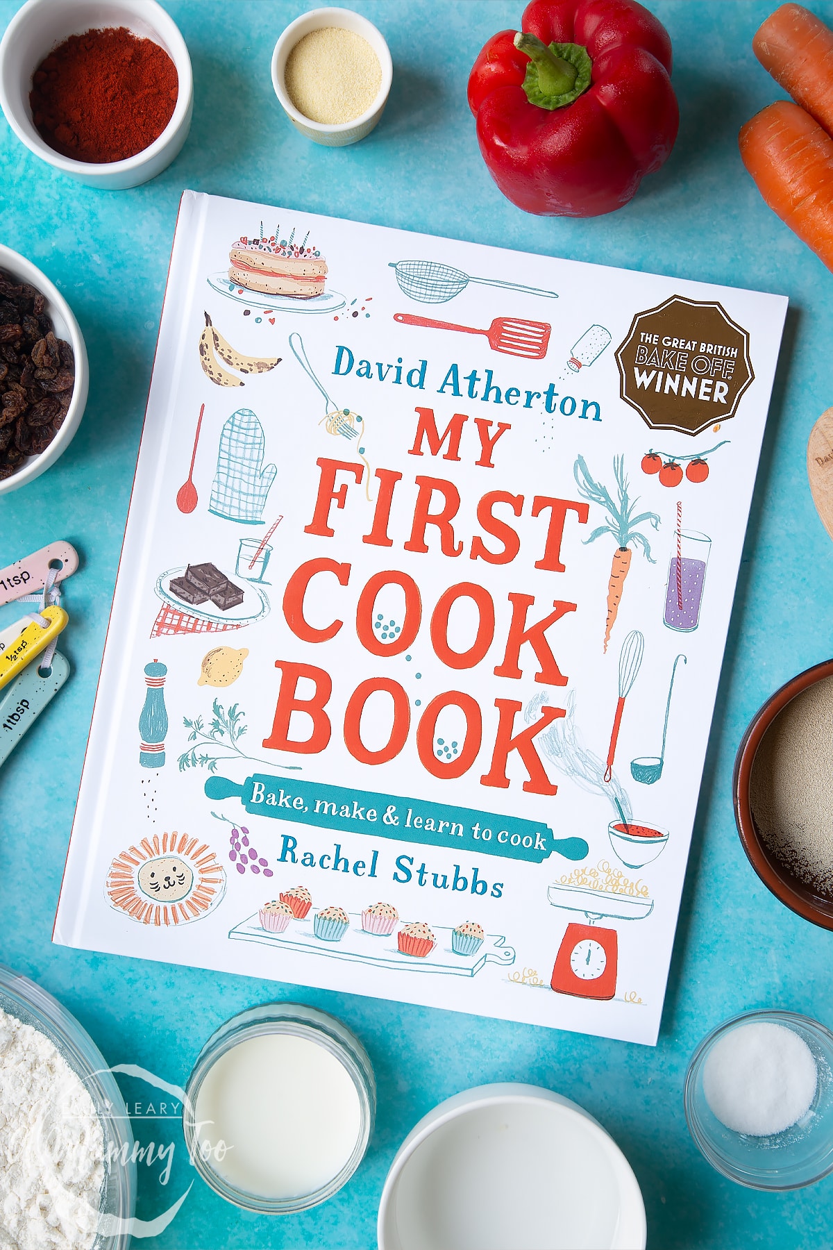David Atherton's My First Cook Book on a blue background surrounded by ingredients to make bread snakes.
