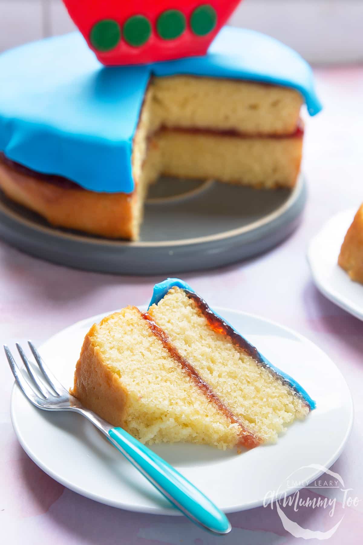 Close up slice of cake on a white plate with a fork on the side.