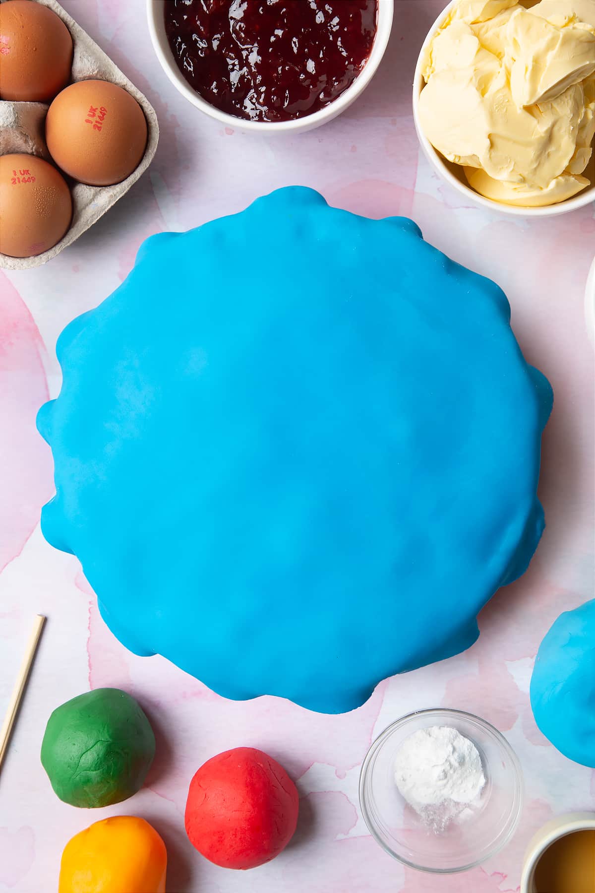Adjusting the blue sugar paste on the top of the cake.