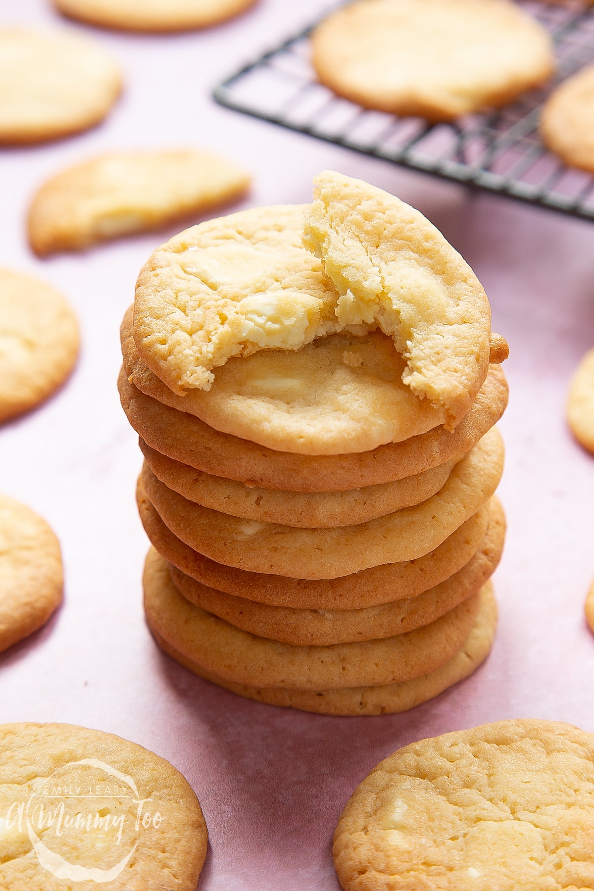 Overhead shot of a broken white chocolate chip cookie on a stack of additional white chocolate chip cookies.