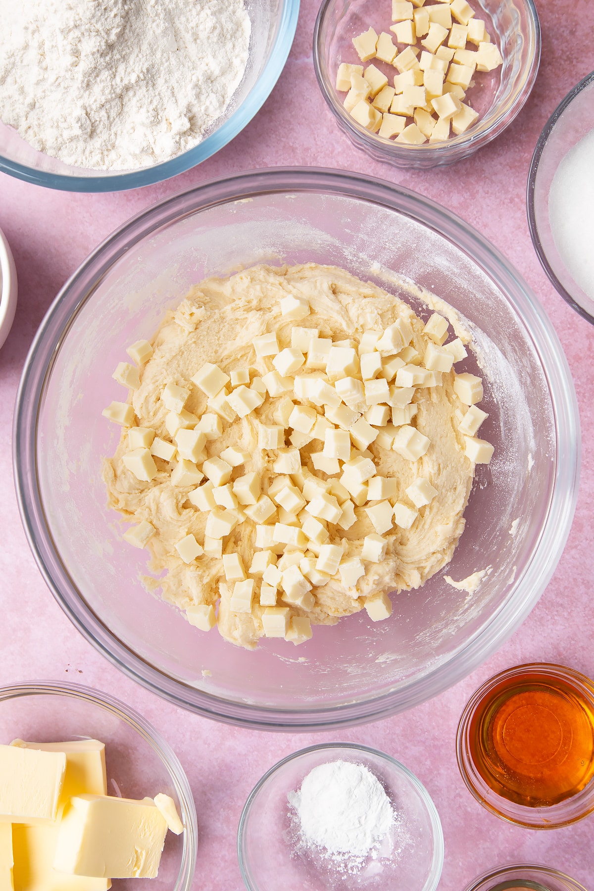 Overhead shot of cookie dough and white chocolate chips in a clear bowl