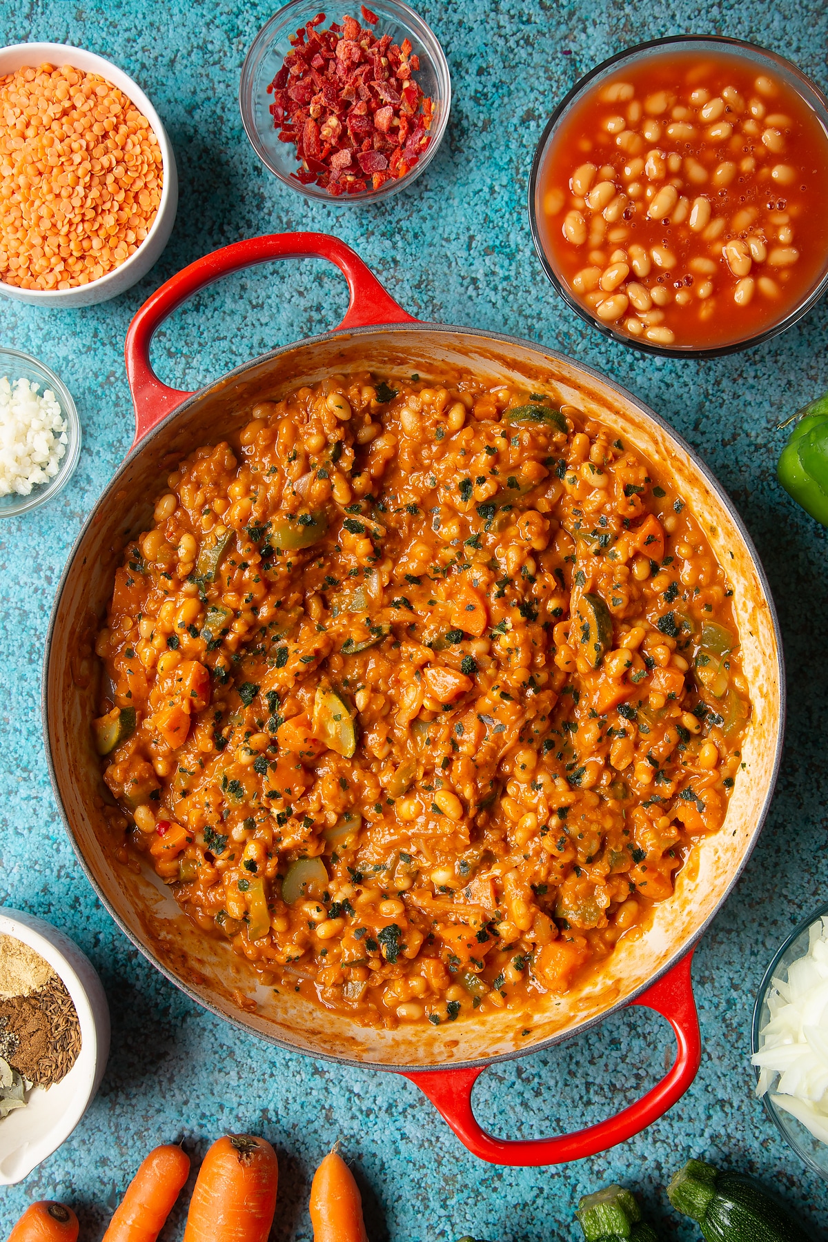 Baked bean curry in a red pan.
