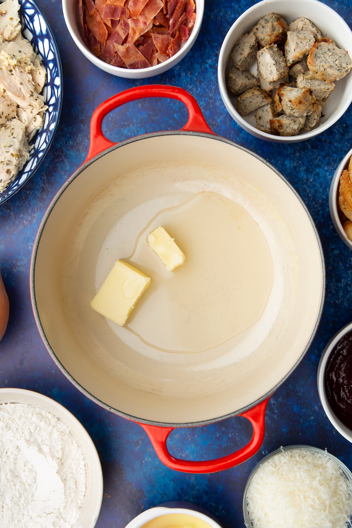 Butter and oil in a pan. Ingredients to make a leftover Christmas dinner pie surround the pan.