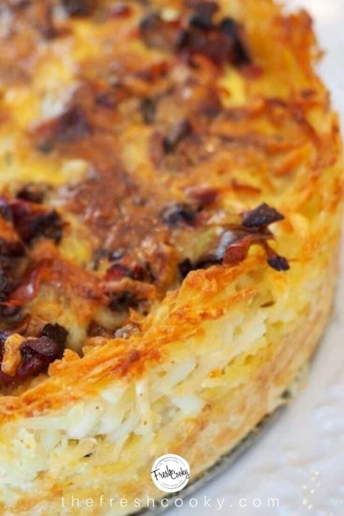 A close up of Prosciutto & Gruyere Quiche With Hash Brown Crust on a white background.