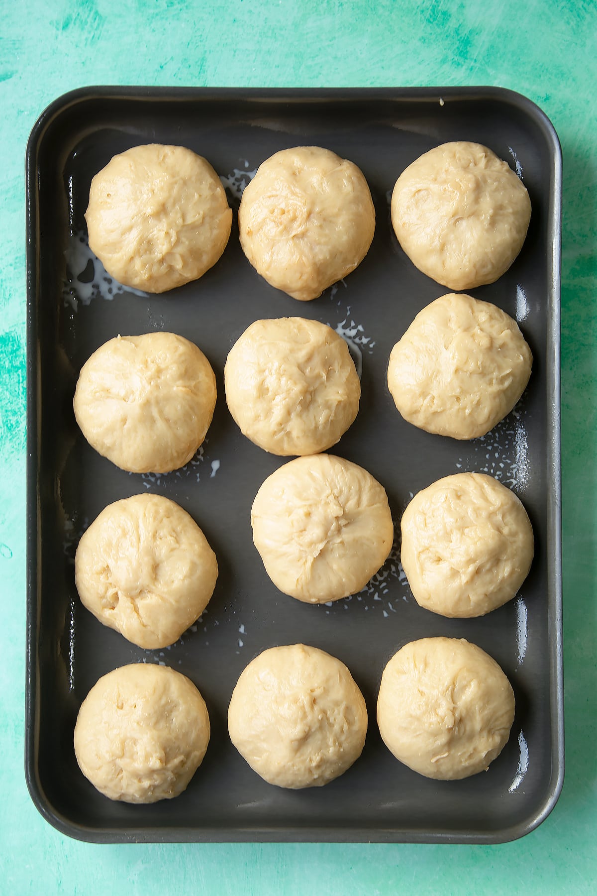 Freshly formed balls of doughy chicken doughnuts on a tray.