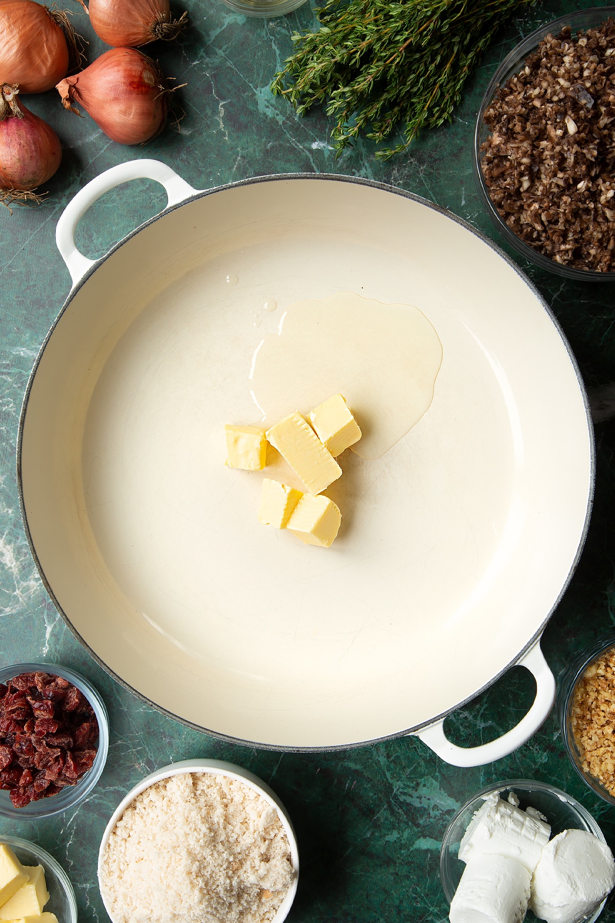 Overhead shot of butter cubes and oil in a large frying pan