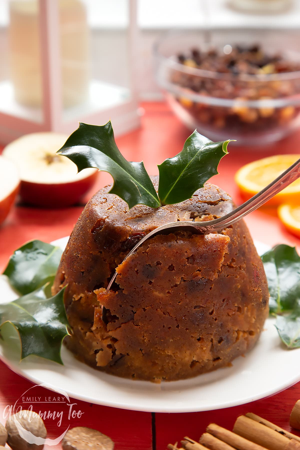 Front angle shot of Alcohol-free Christmas pudding served on a white plate with a mummy too logo in the lower-left corner