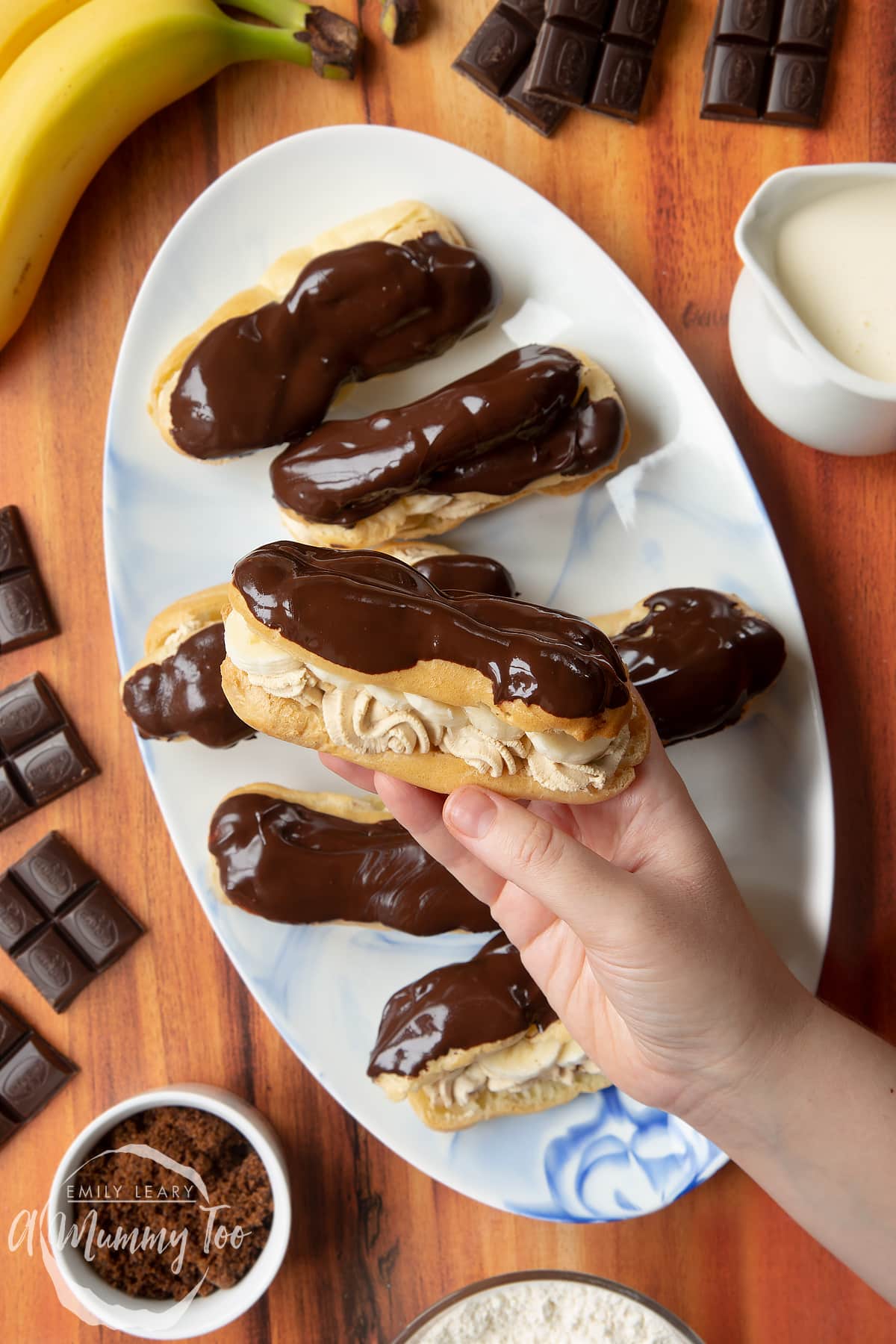 Hand holding one of the finished banoffee eclairs.