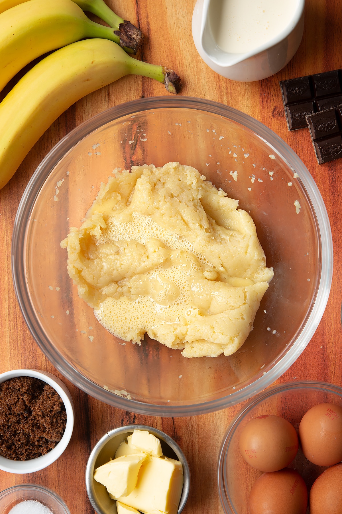 Overhead shot of choux with eggs in a large clear bowl