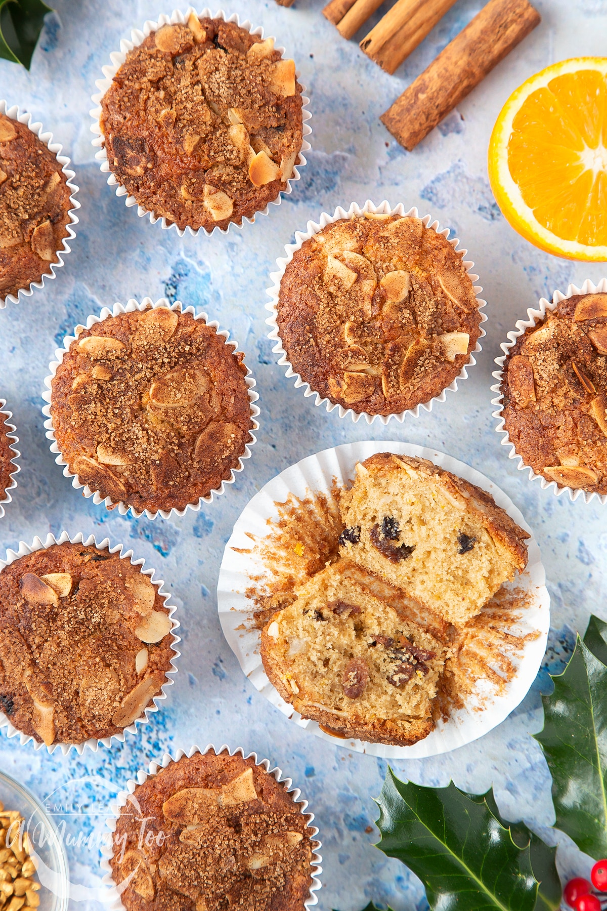 Overhead shot of orange and cinnamon muffin cut in half open with the A Mummy Too logo in the corner