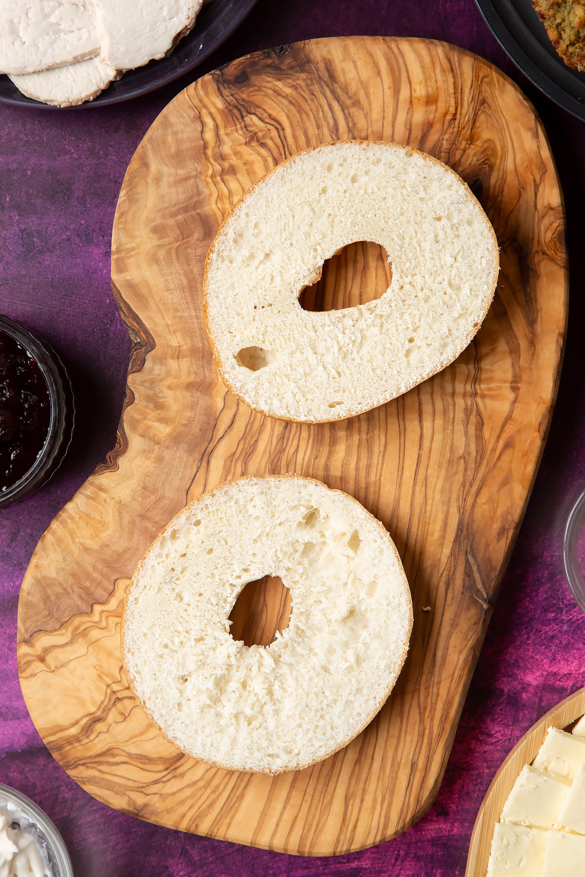 Overhead shot of halved turkey bagel served on a wooden plate