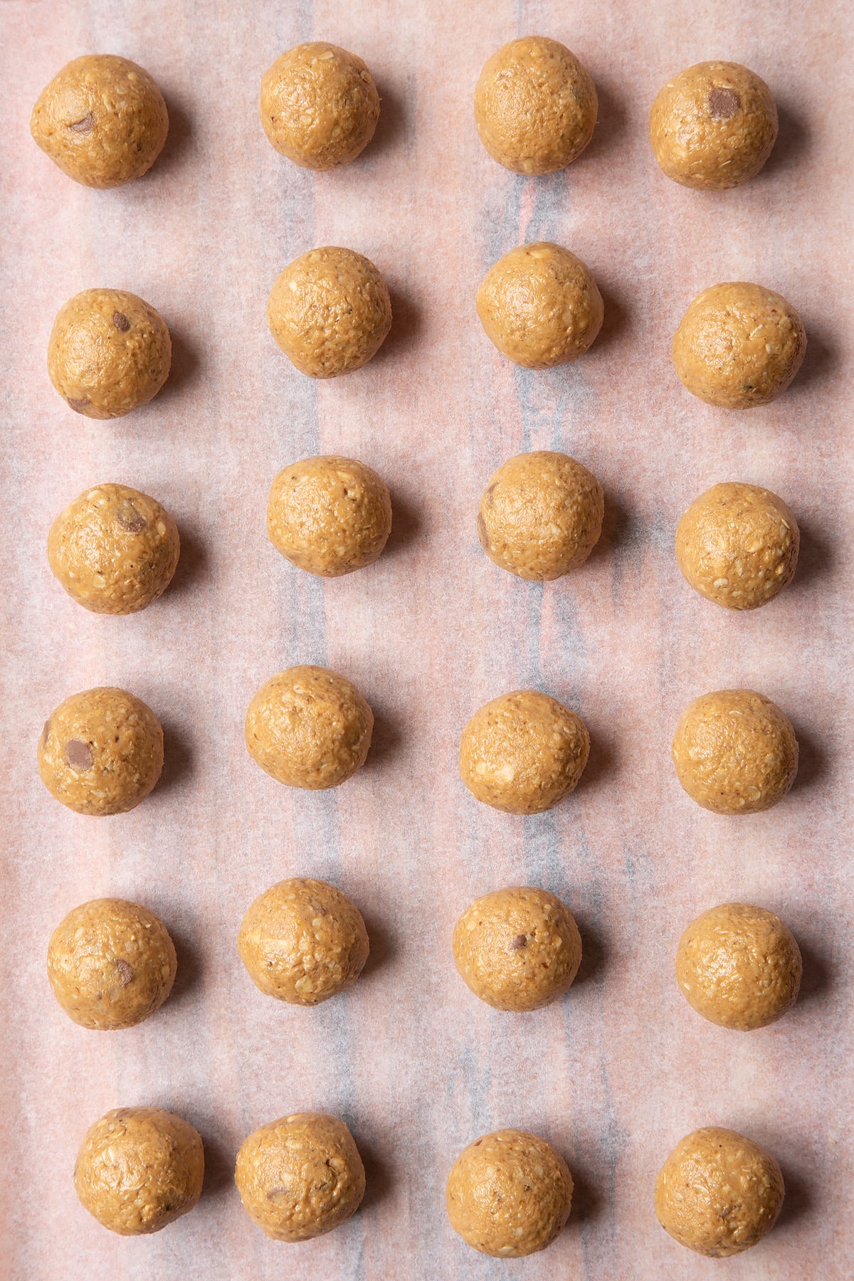 Peanut butter and oatmeal balls on a sheet of baking paper.