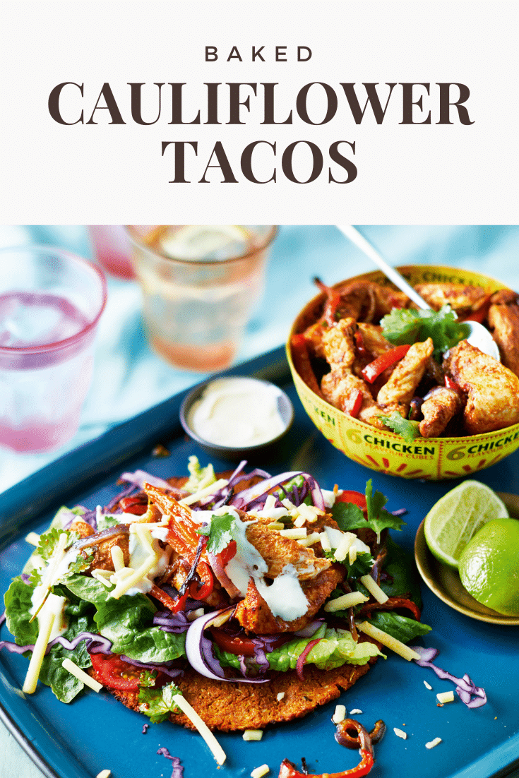A cauliflower taco with salad and chicken on a blue tray. A bowl of chicken and vegetable filling is shown in the background. Limes are on a small plate. The caption reads: Baked cauliflower tacos