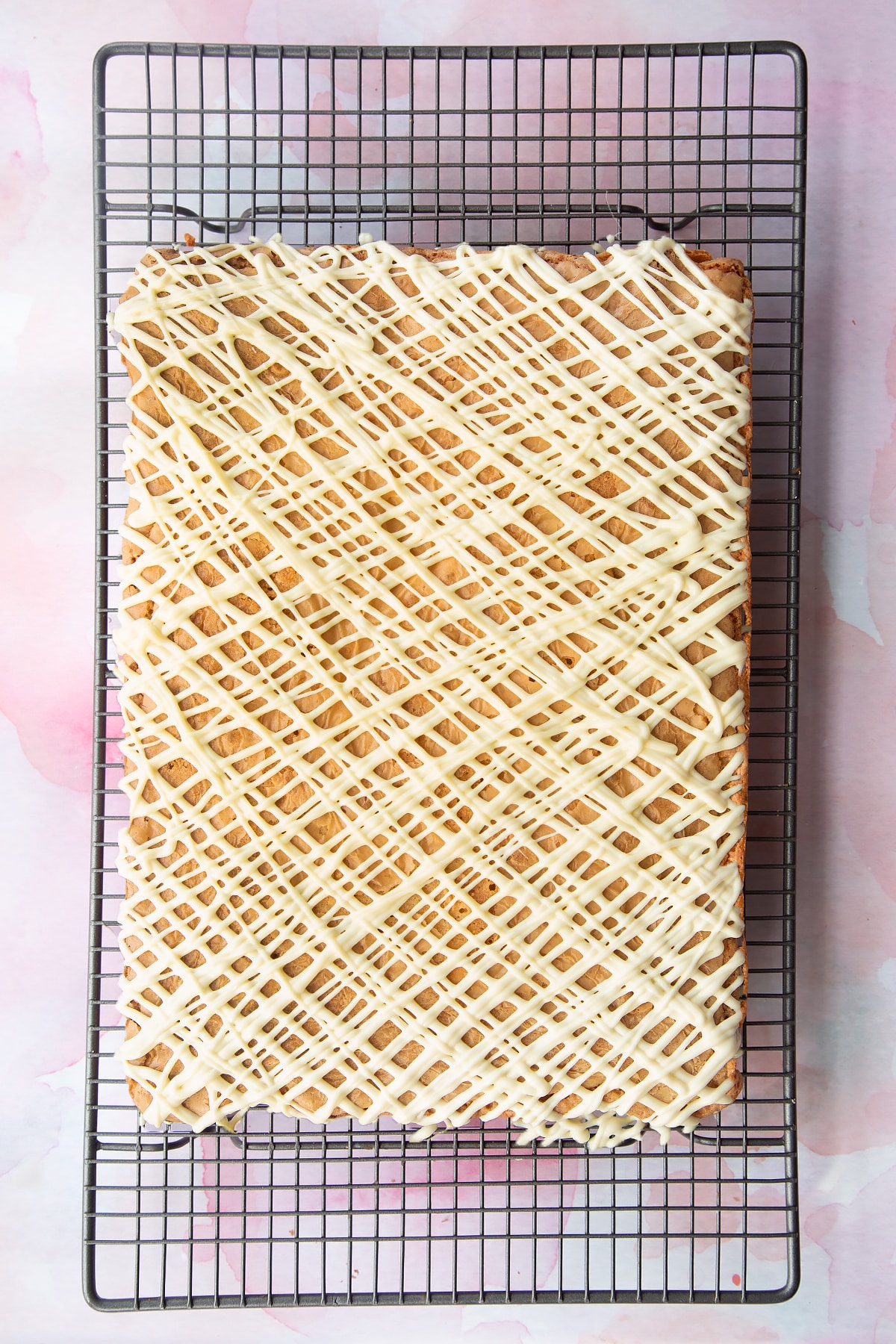 Mini Egg blondies on a wire rack, drizzled with white chocolate.