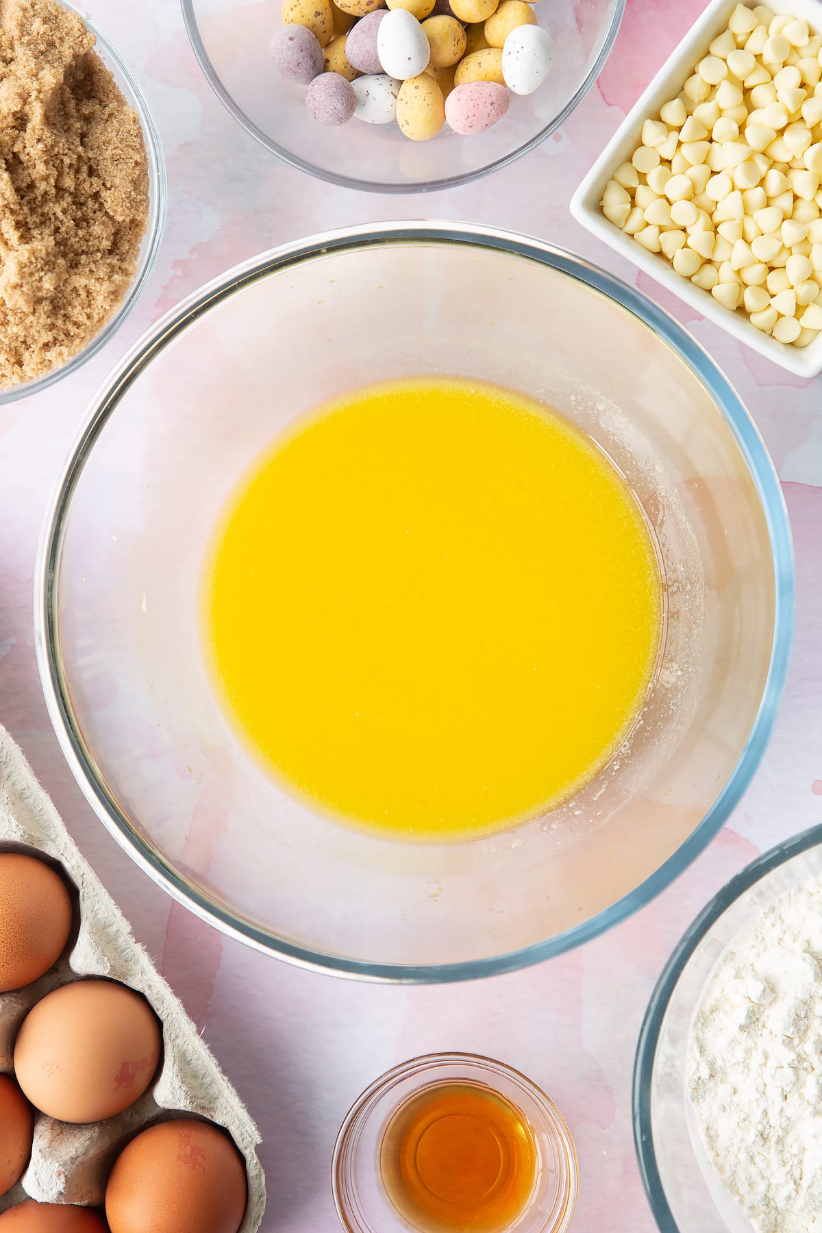 Melted butter in a bowl. Ingredients to make Mini Egg blondies surround the bowl.