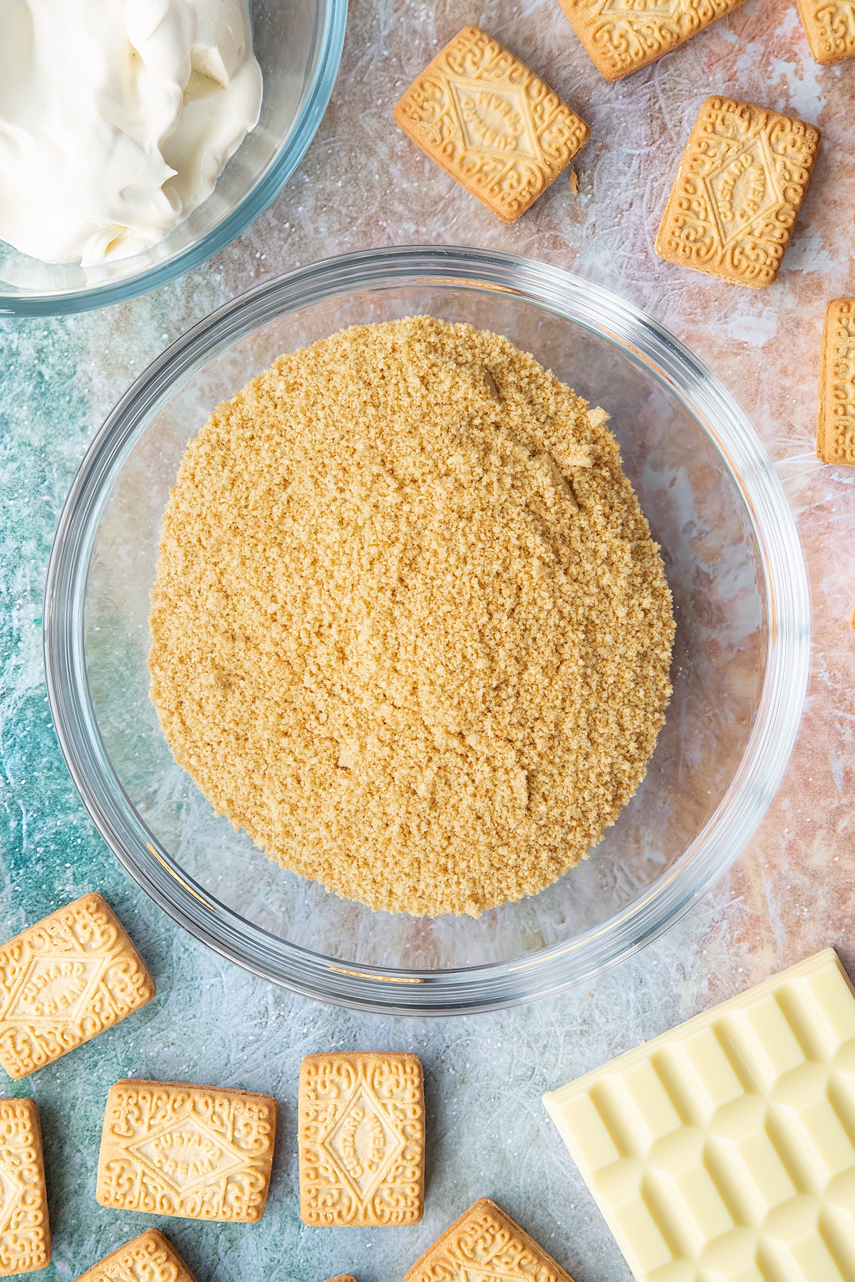 OVerhead shot of biscuit crumbs in a large clear bowl