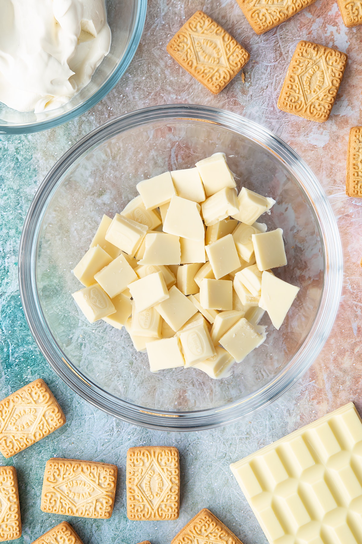 Overhead shot of pieces of white chocolate in a large clear bowl