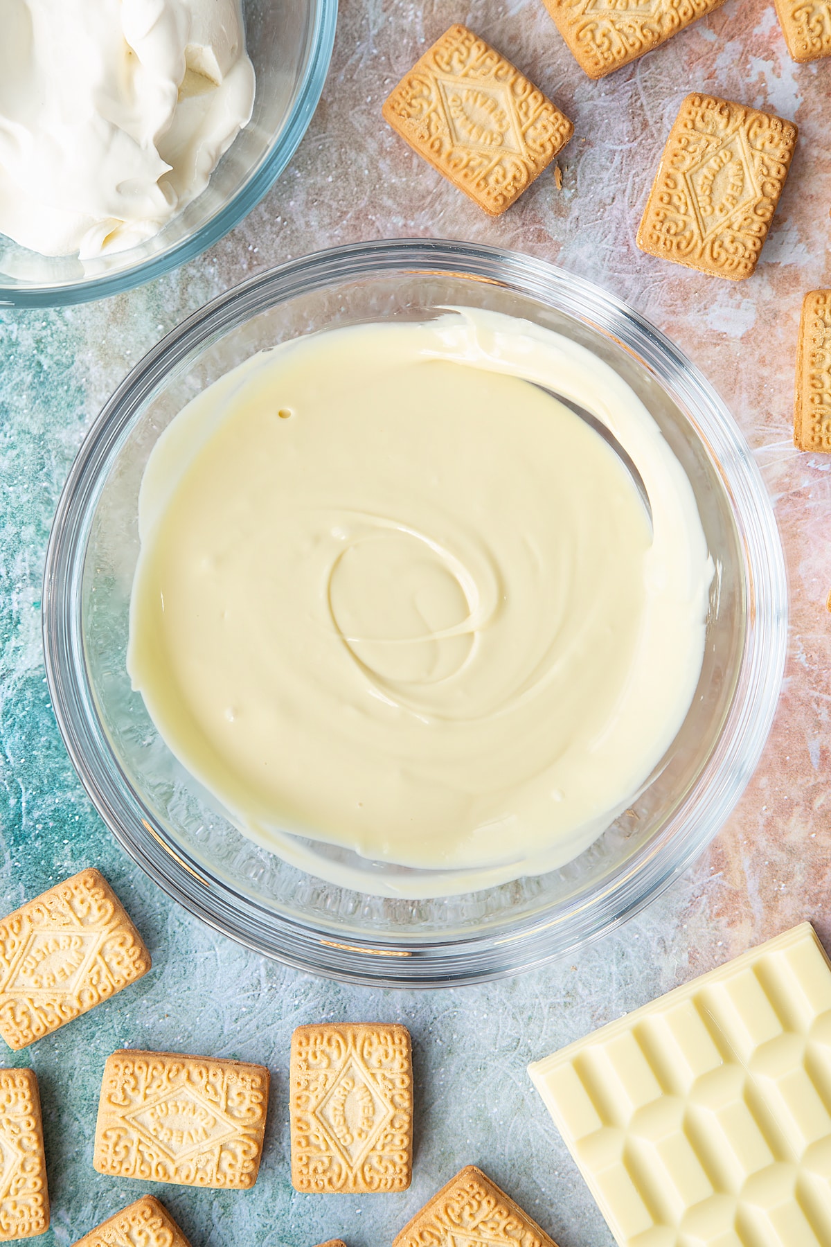 Overhead shot of melted white chocolate in a large clear bowl
