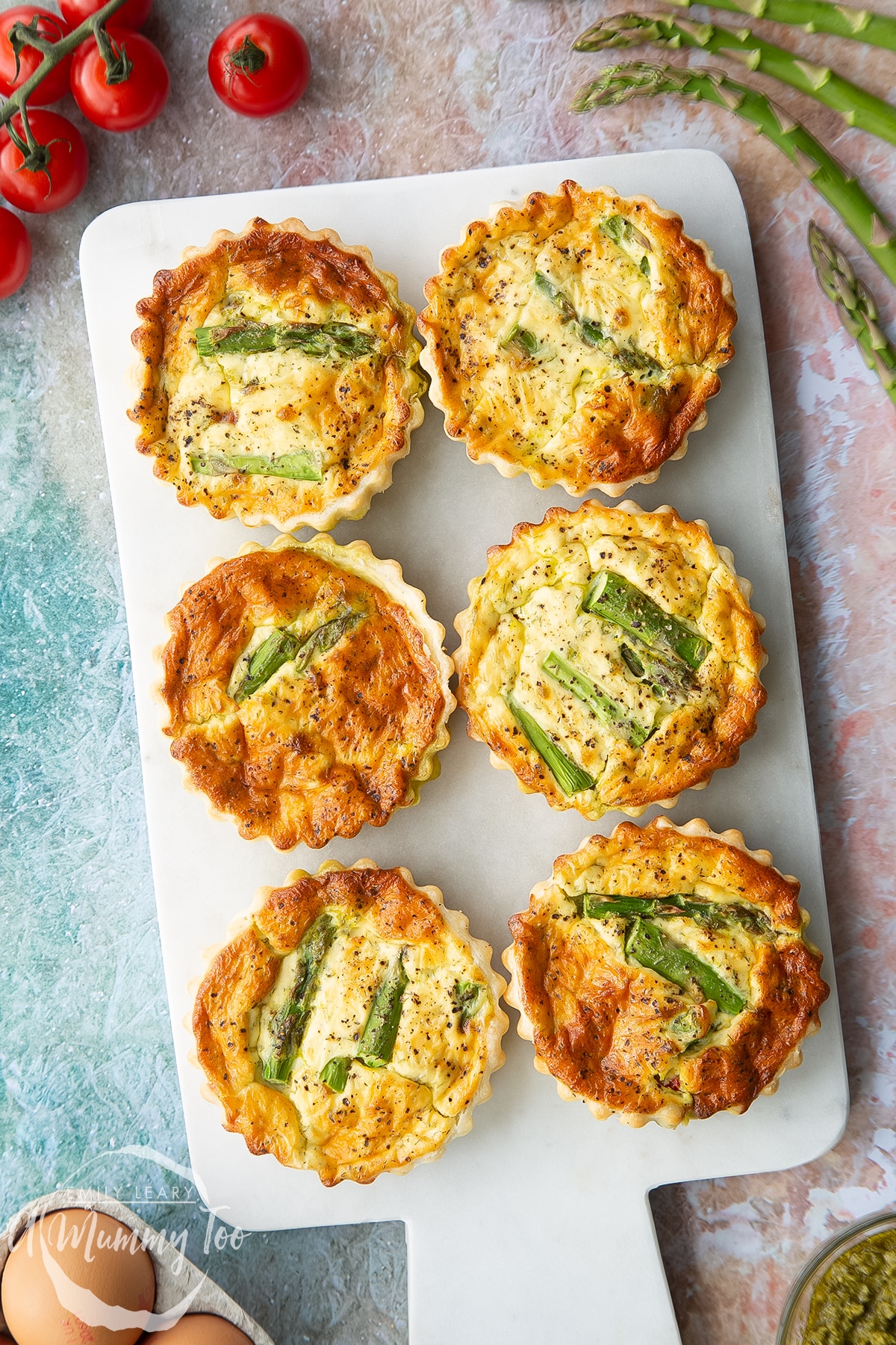 Asparagus tartlets on a white marble board. Shown from above.