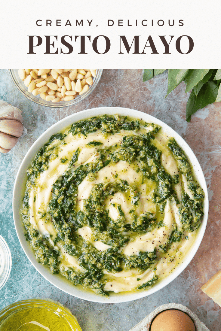 Pesto mayo in a white bowl. The pesto and mayonnaise are swirled together. Caption: creamy, delicious pesto mayo
