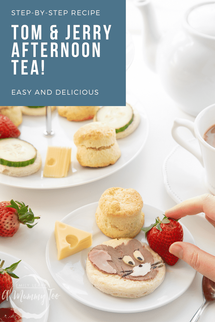 Hand reaching in to grab a strawberry from the plate. Tom and Jerry afternoon tea graphic at the top of the image.
