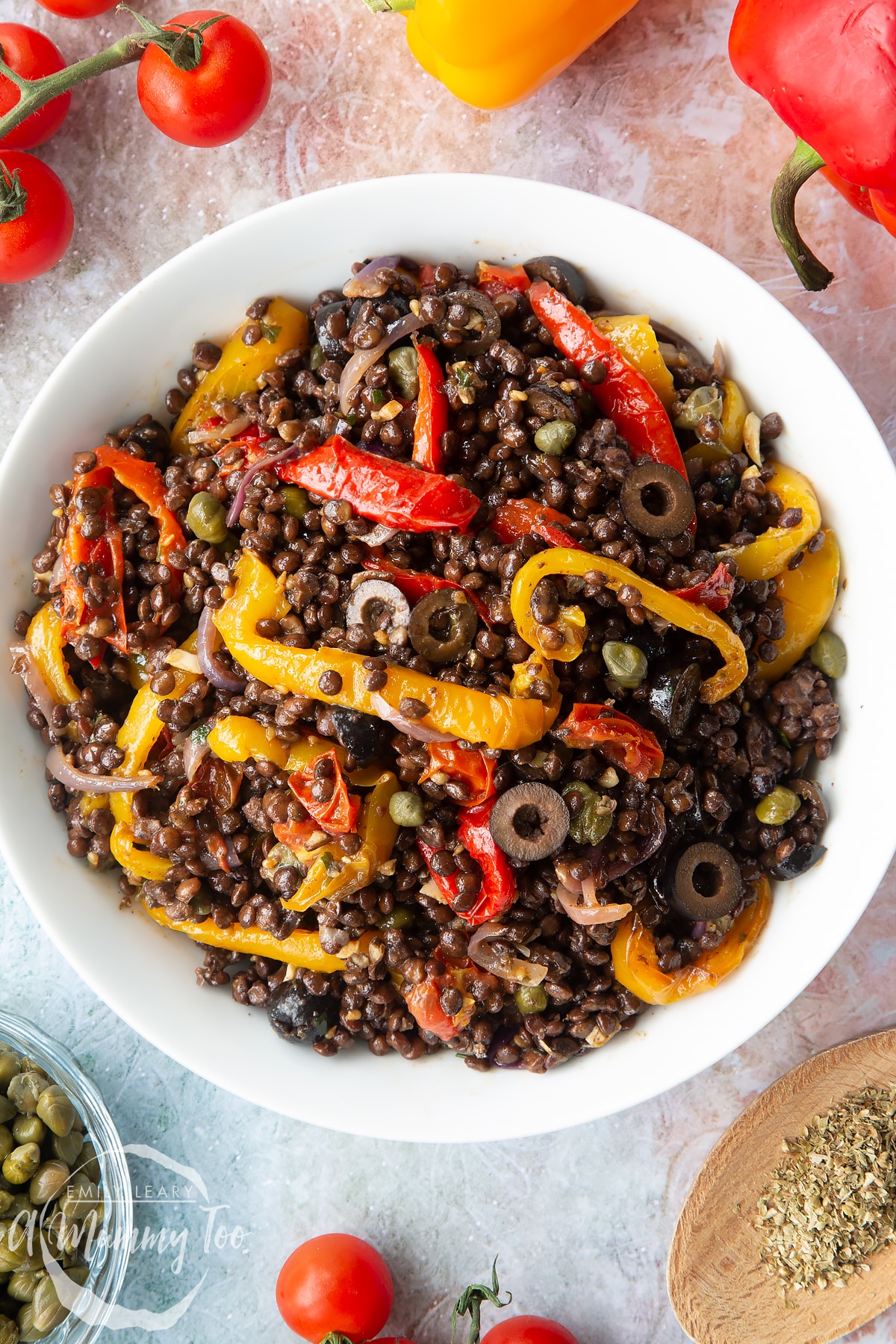 Close up of vegan lentil salad served in a white shallow bowl, shown from above.