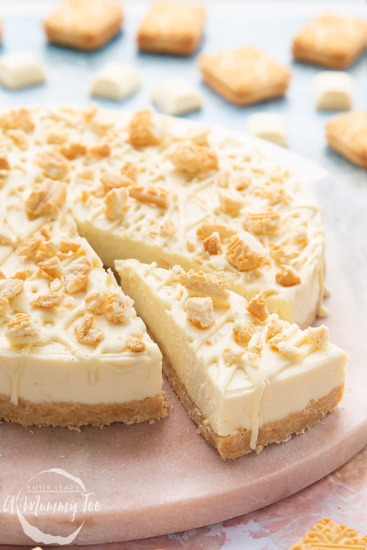 Front view shot of a piece of cheesecake separated from the whole cheesecake on a board