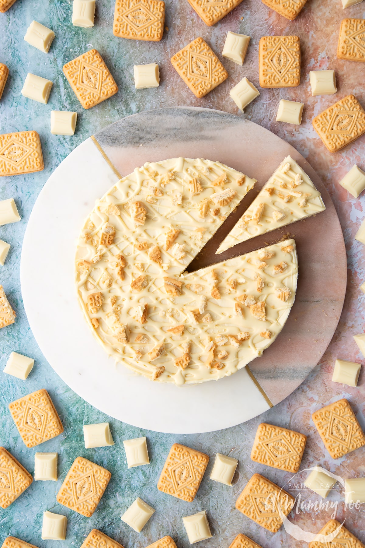 Overhead shot of a cheesecake with a slice cut out surrounded by Custard Cream Biscuits
