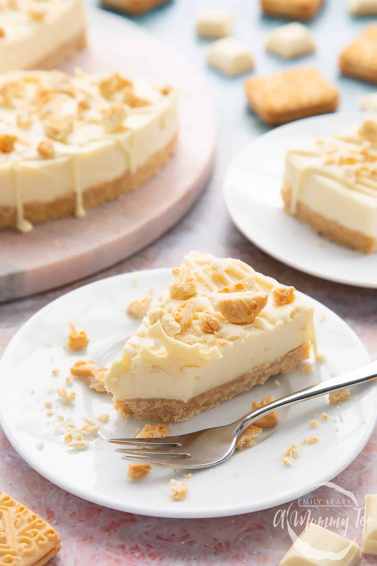 Front view shot of white chocolate cheesecake on a white plate with a fork