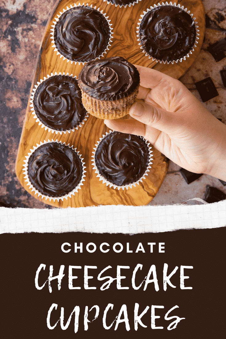 Chocolate cheesecake cupcakes in rows on an olive wood board from above. A hand holds one. Caption reads: chocolate cheesecake cupcakes