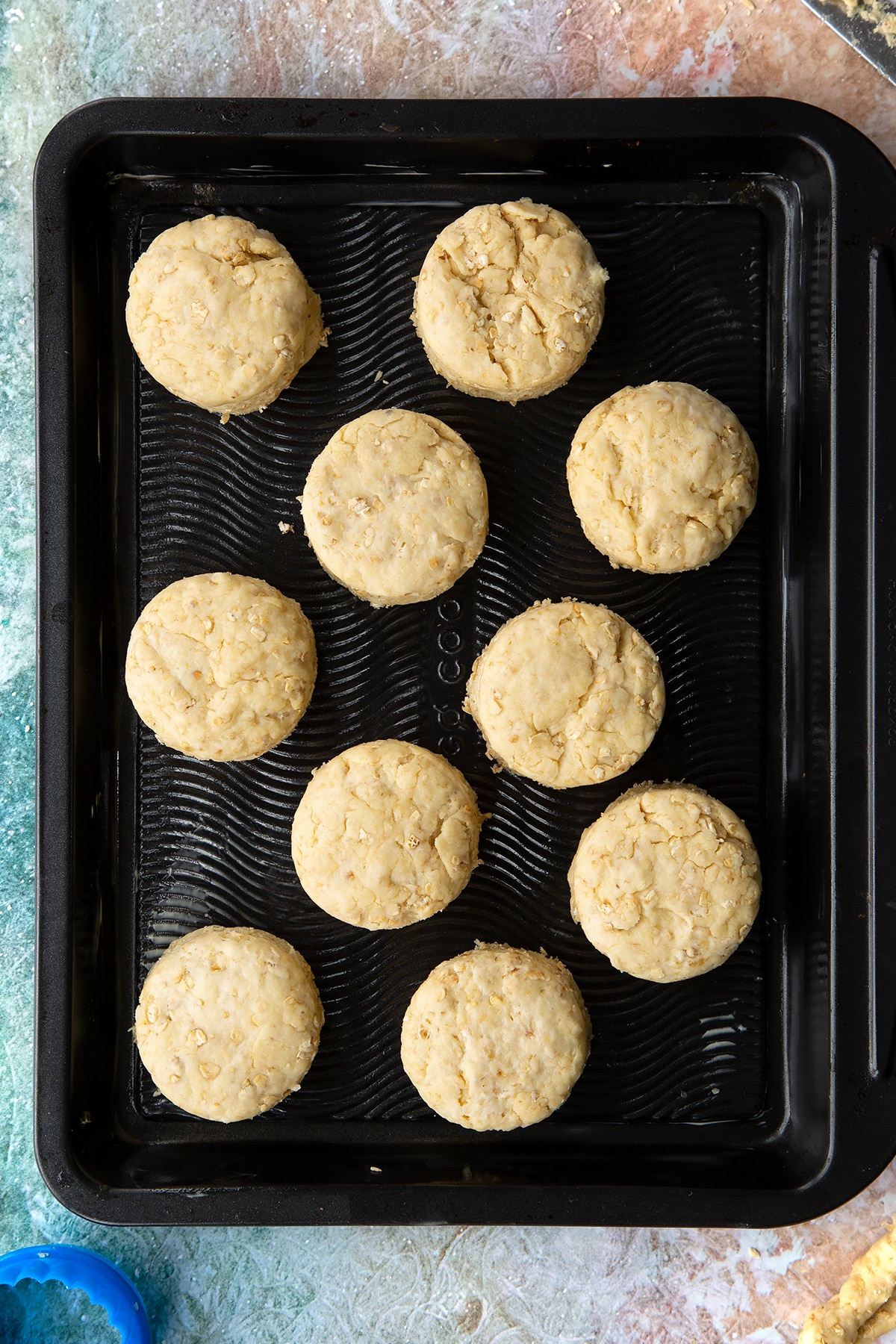 Oatmeal scone rounds of dough on a baking tray.