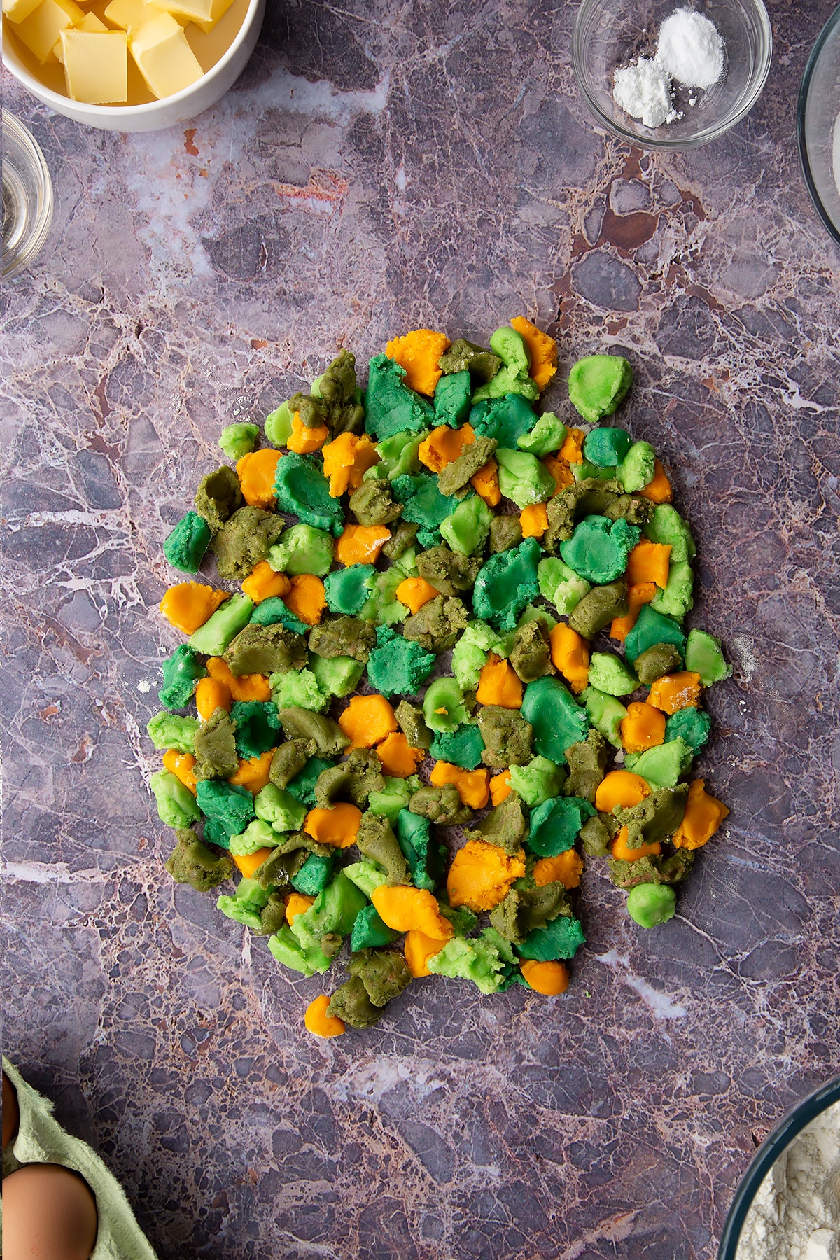 Overhead shot of small chunks of coloured cookie dough pieces laid out together on a surface
