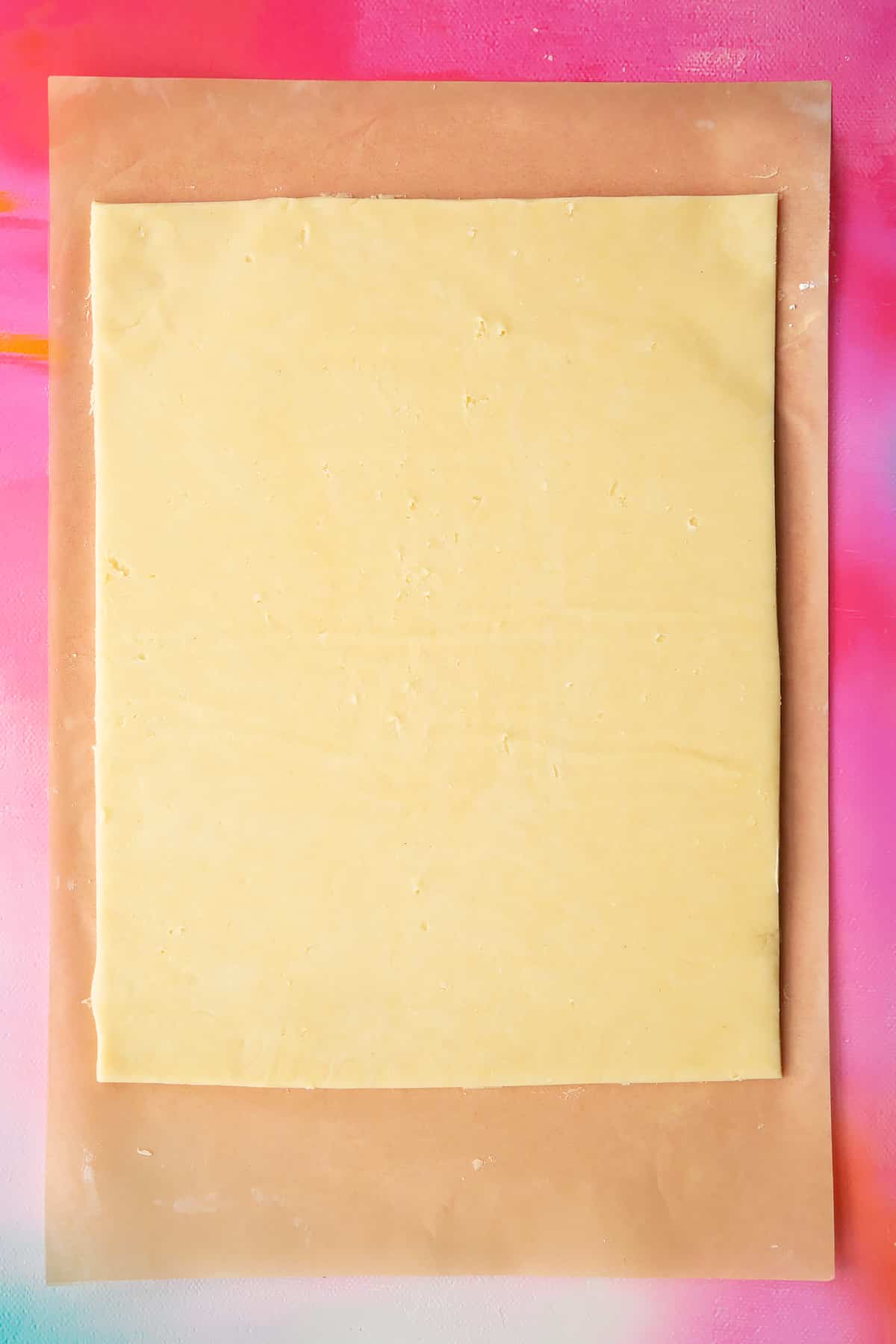 A neat rectangle of gluten free pasty rolled out on a sheet of baking paper.