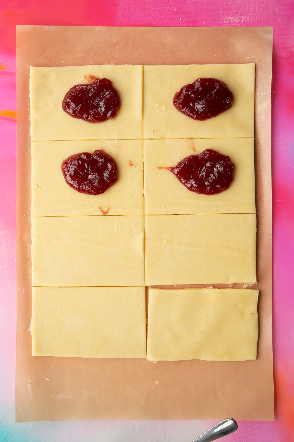 Gluten free pasty rolled out, cut into eight pieces and topped with spoonfuls of jam.