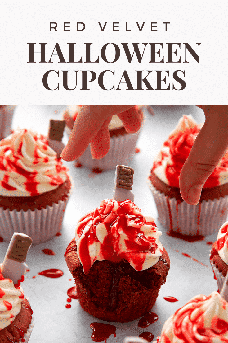 Red velvet Halloween cupcake, spattered with red syrup, with a bite out of it. A hand reached for it. Caption reads: Red velvet Halloween cupcakes.