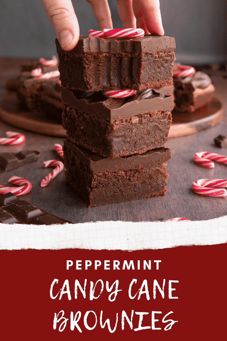 A stack of candy cane brownies. A hand reaches for one with a bite out of it. Caption reads: Peppermint candy cane brownies.
