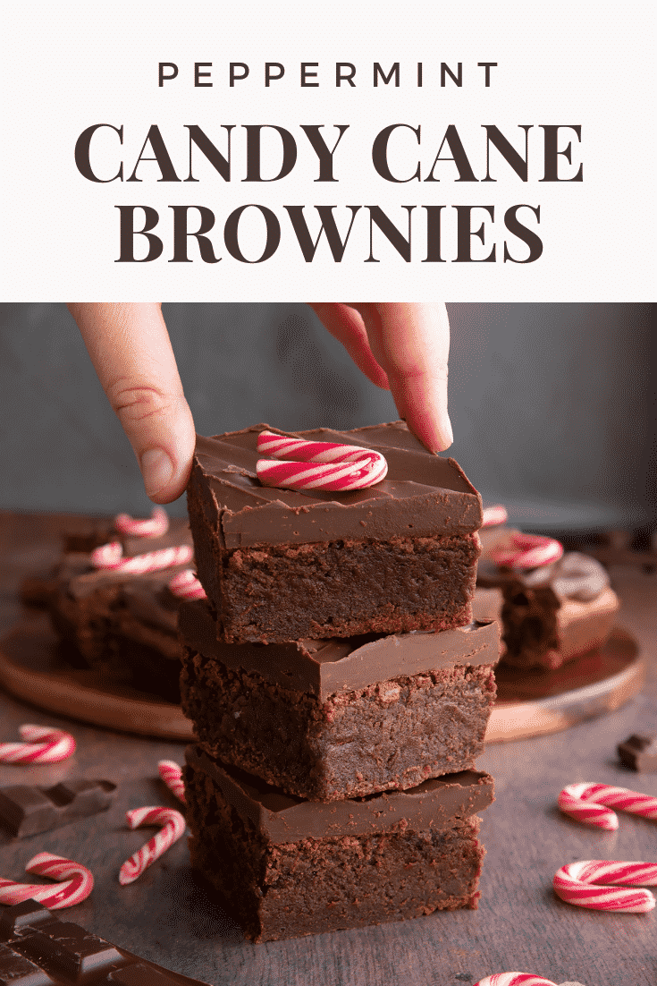 A stack of candy cane brownies. A hand reaches for one. Caption reads: Peppermint candy cane brownies.