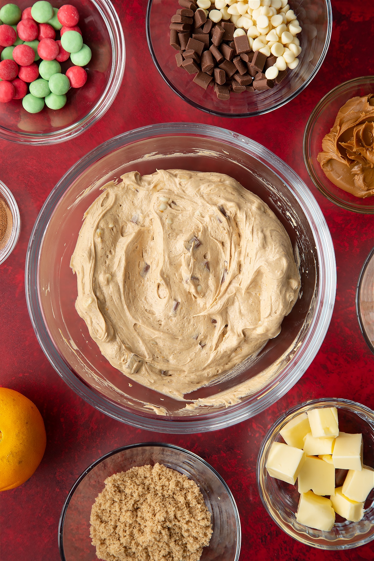 Christmas cookie dip in a mixing bowl. Ingredients to make Christmas cookie dip surround the bowl.