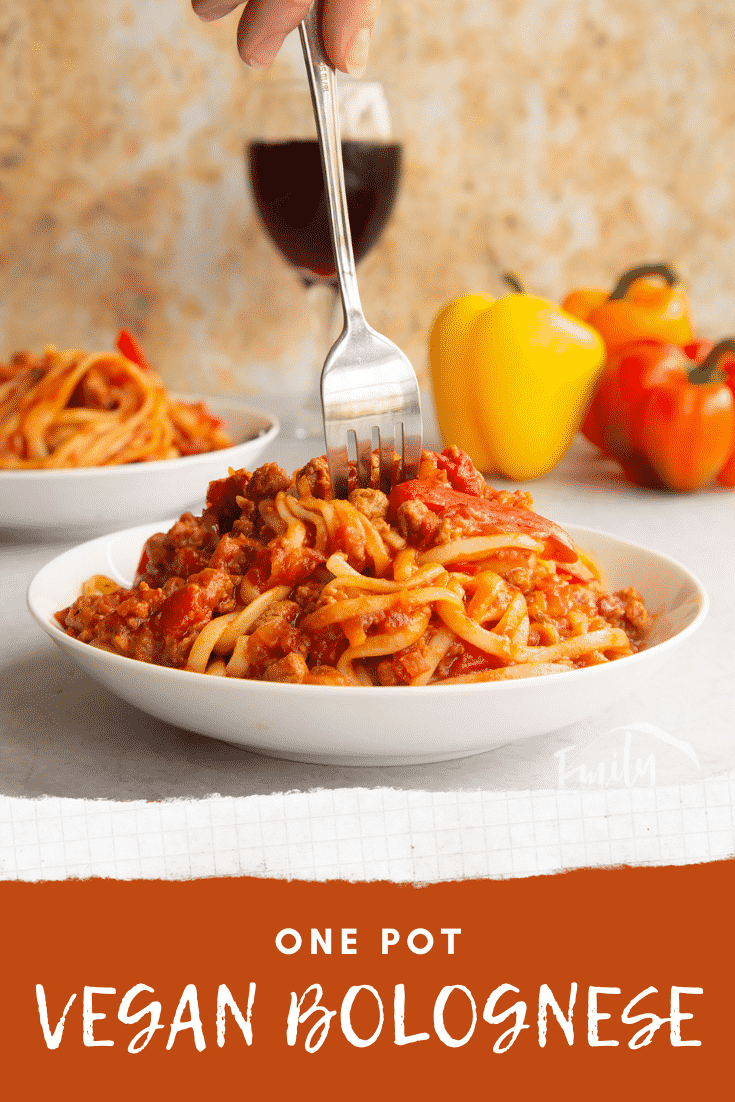 One pot vegan bolognese in a shallow white bowl. A hand delved a fork into the bowl. Caption reads: one pot vegan bolognese