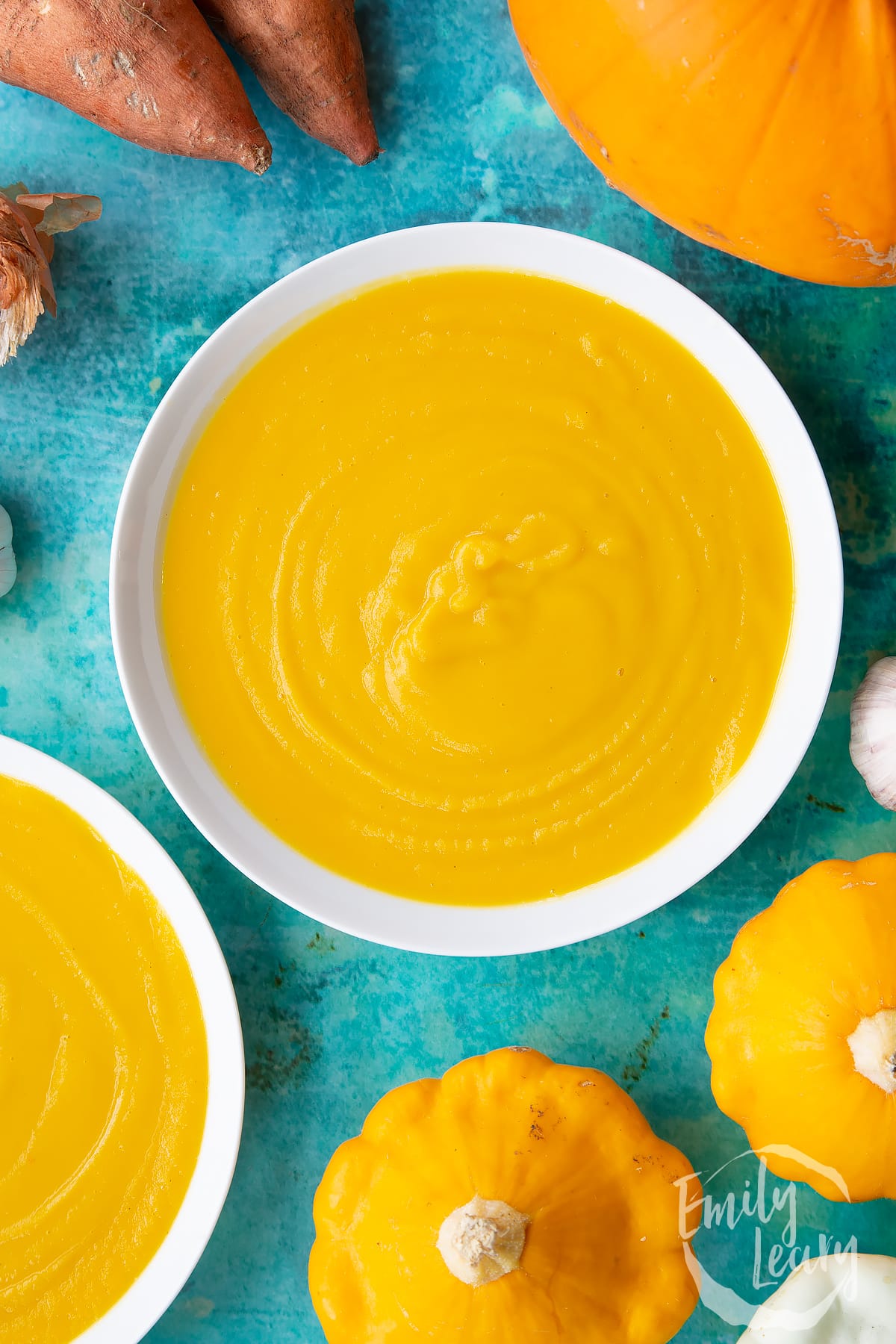 Pumpkin and sweet potato soup in a white bowl, from above.