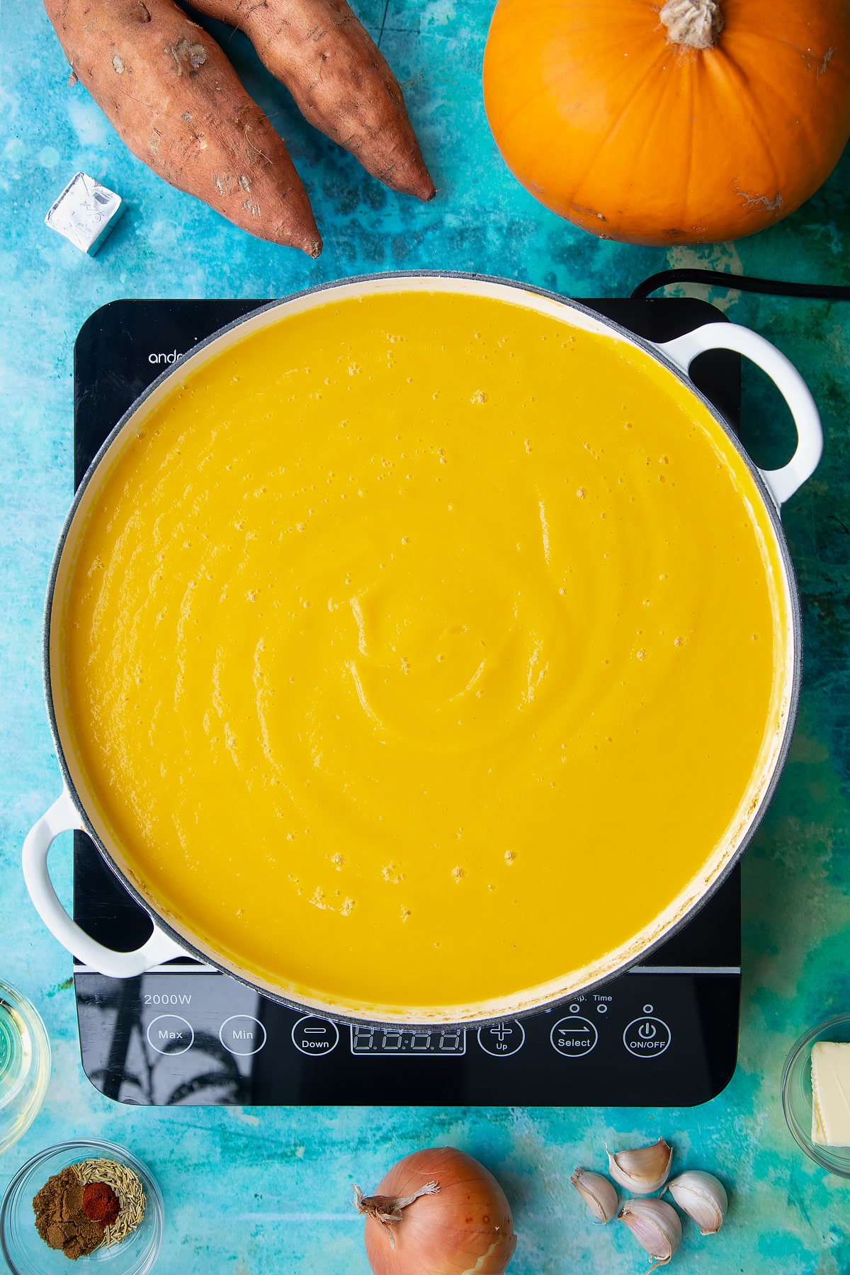 Pumpkin and sweet potato soup in a large, shallow pan, from above.