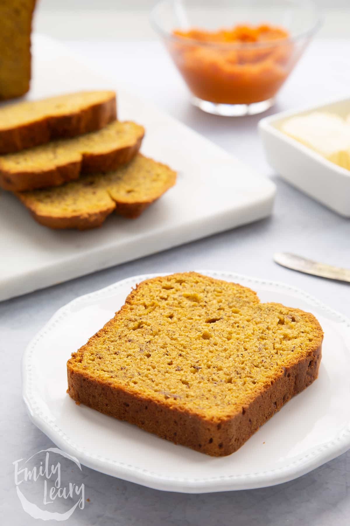 Slice of pumpkin banana bread on a white plate.