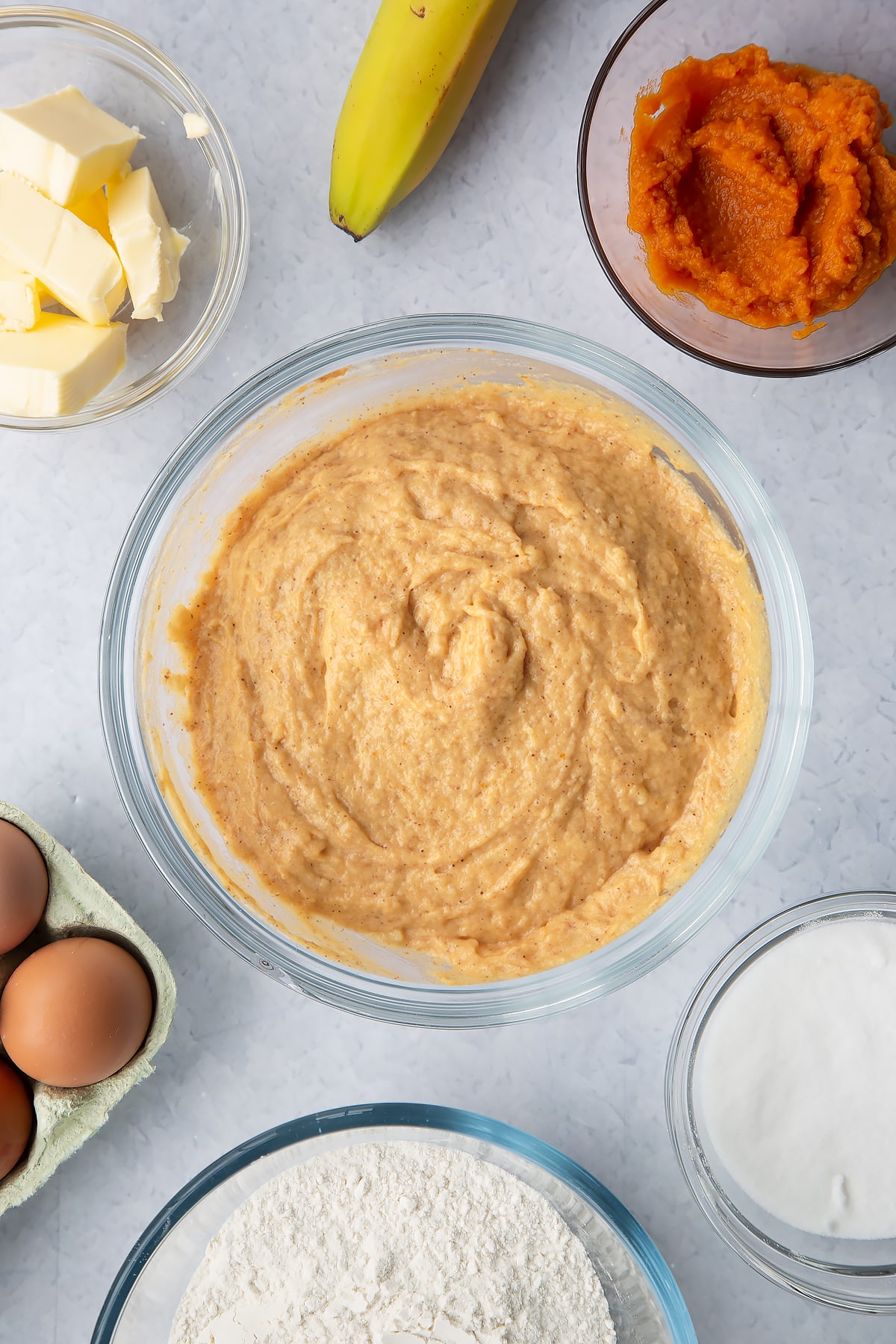 Pumpkin banana bread batter in a glass mixing bowl.