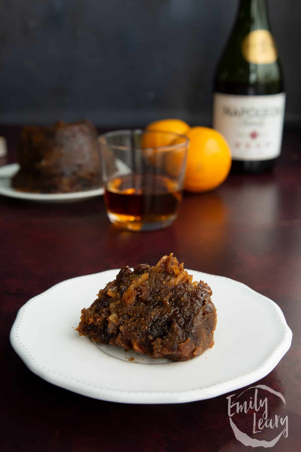 A piece of vegan Christmas pudding on a small white plate.