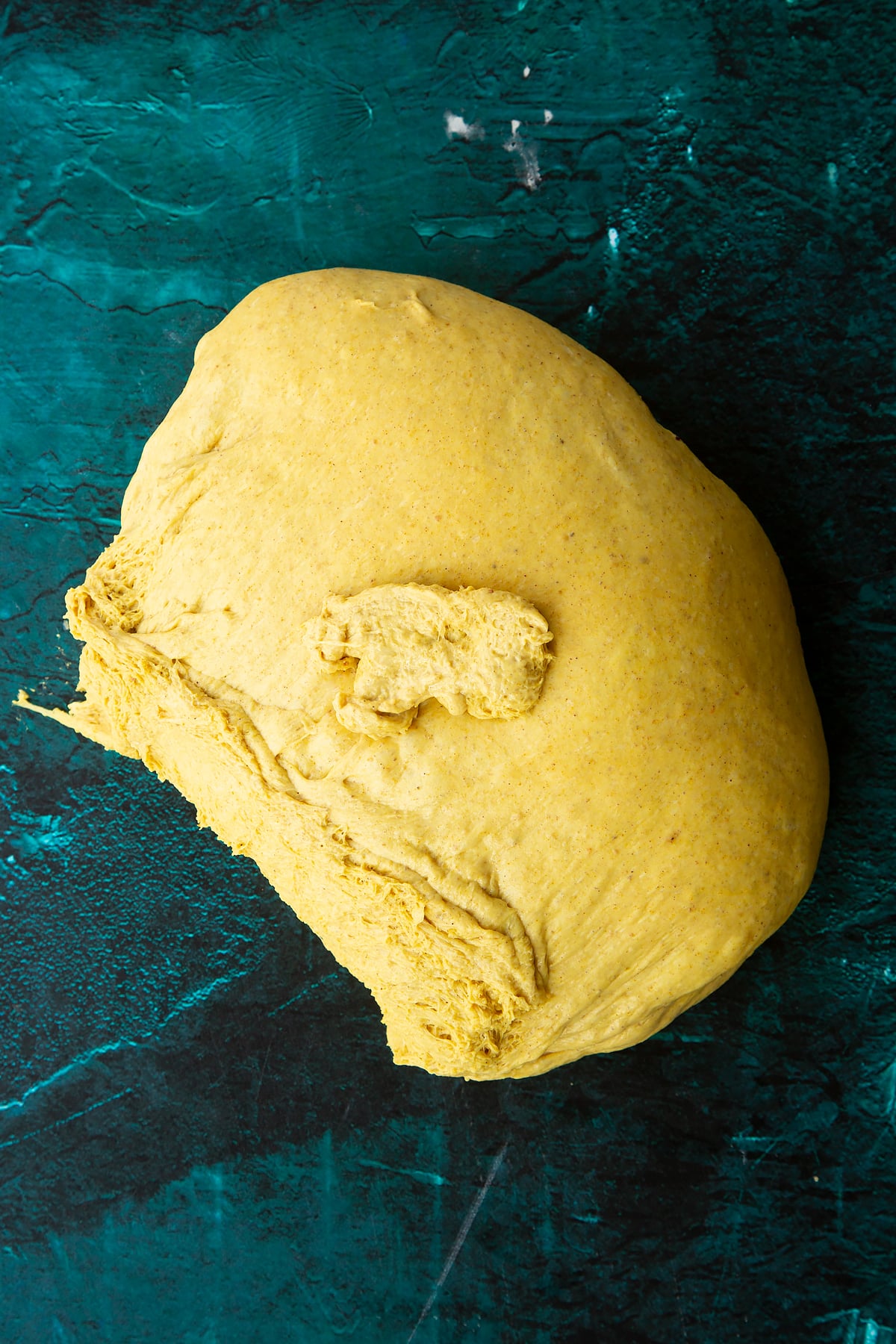 Risen pumpkin sourdough tipped onto a clean surface.