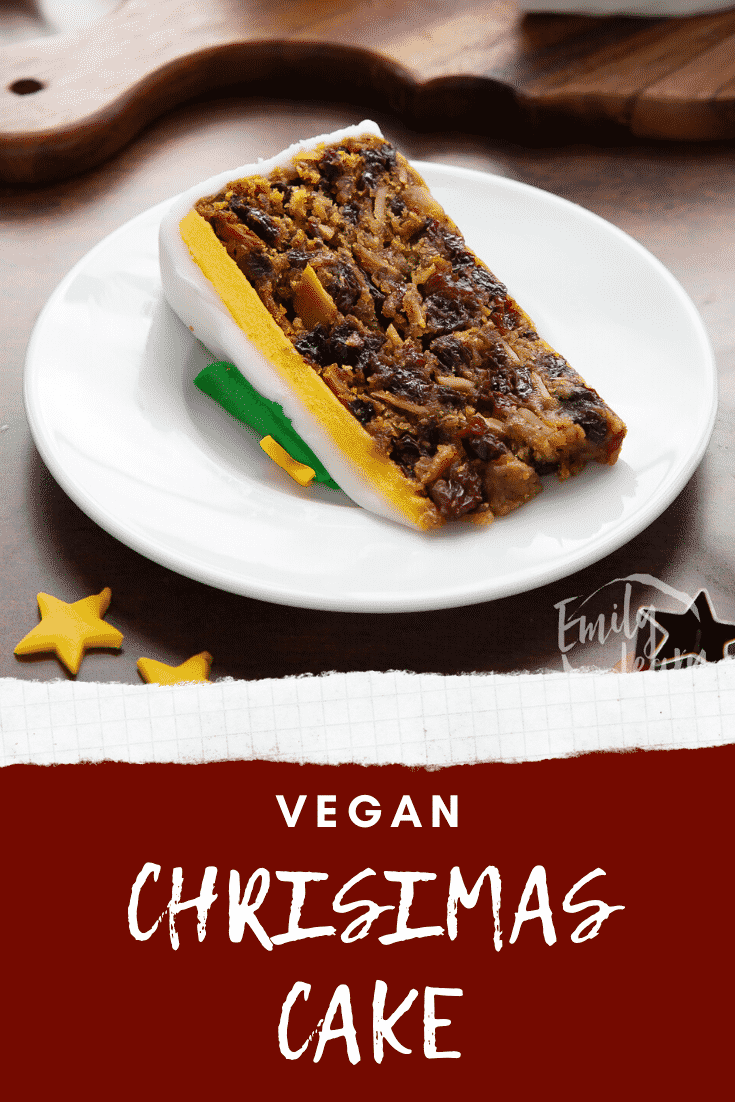 Slice of vegan Christmas cake on a white plate. Caption reads: Vegan Christmas cake.