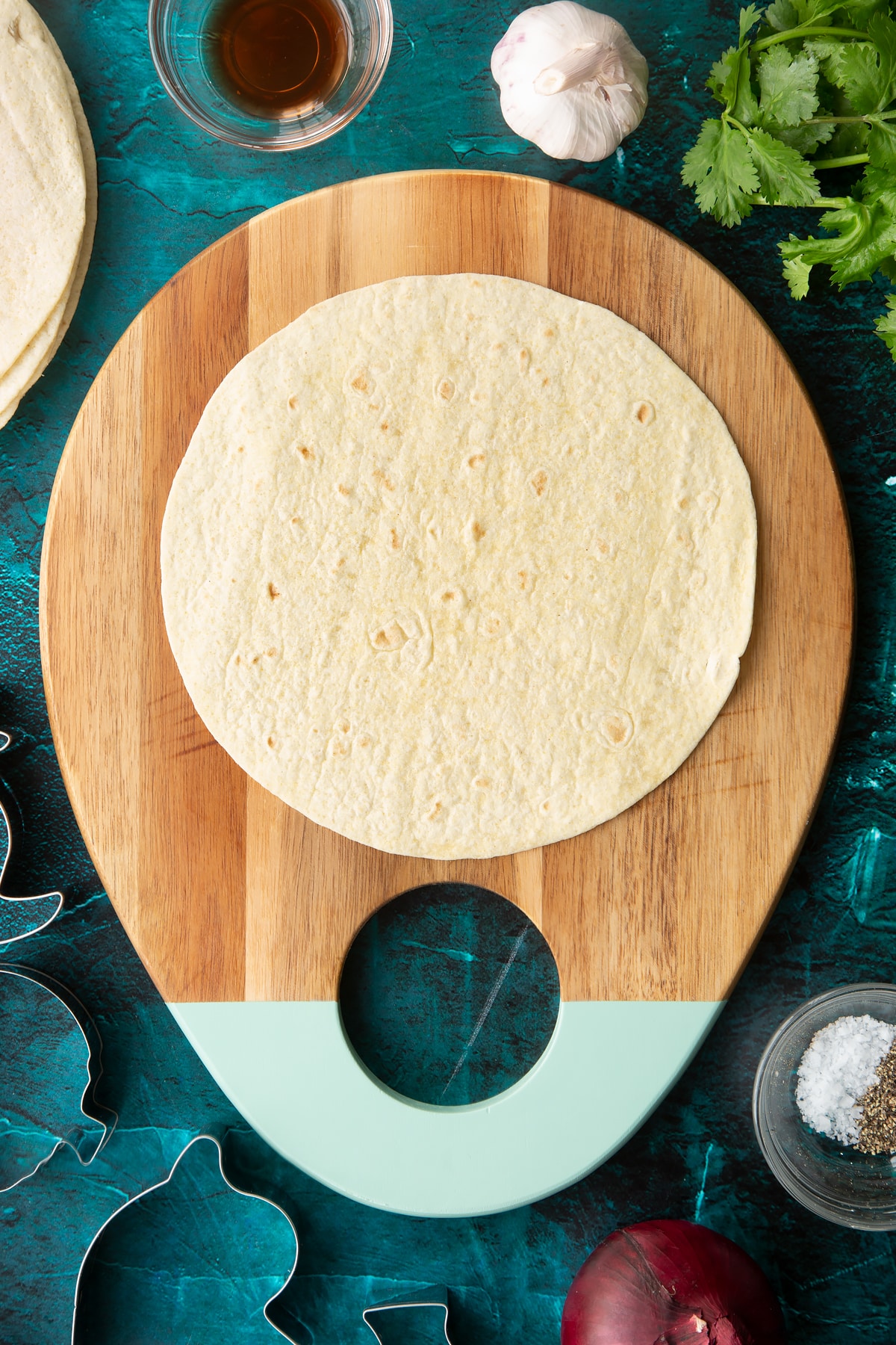 A soft, round tortilla on a board.