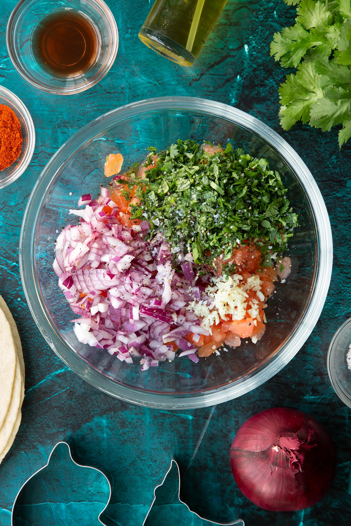 Chopped tomatoes, red onion, coriander, garlic, red wine vinegar and lime juice in a glass bowl