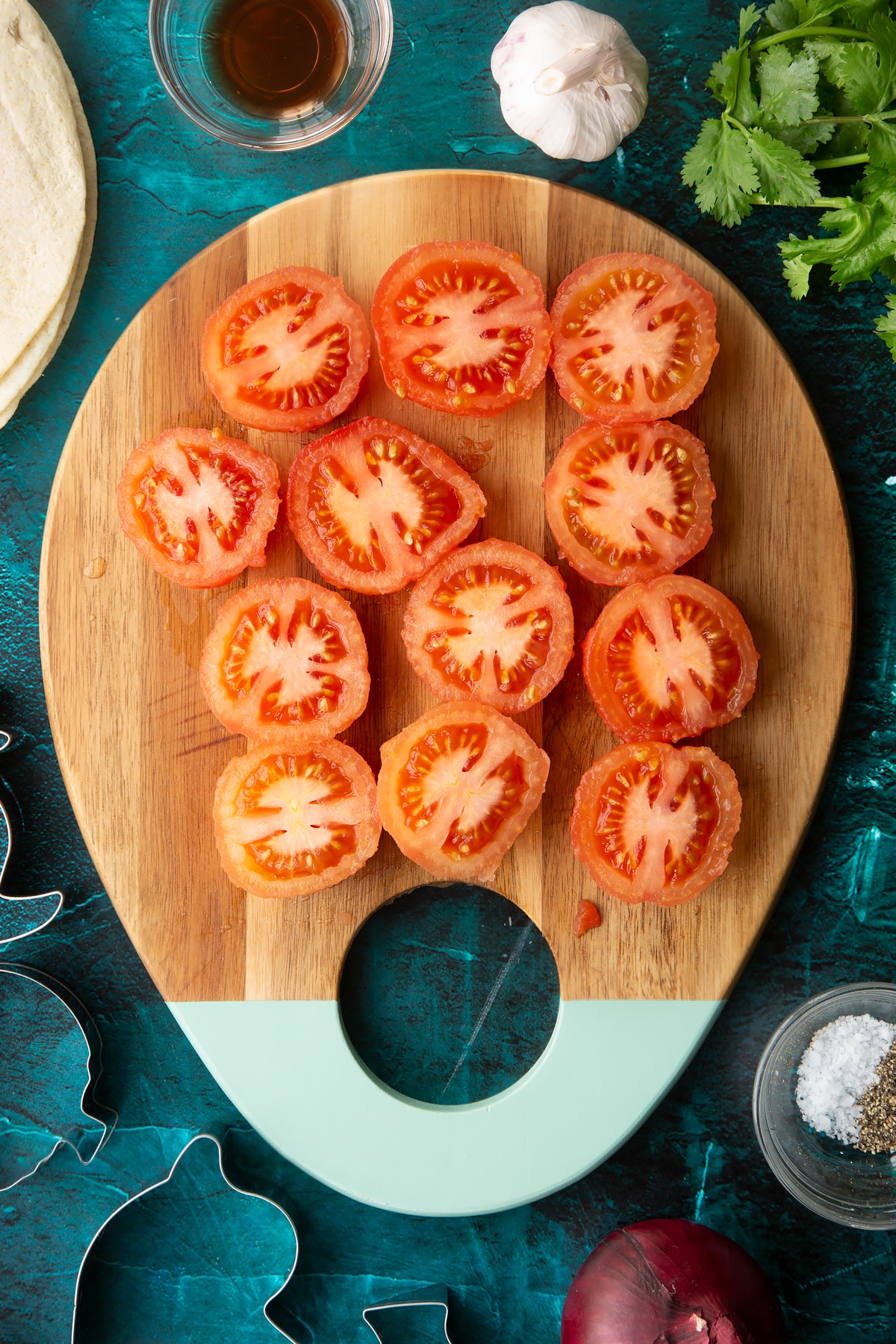 Peeled tomatoes, cut in half on a wooden board.