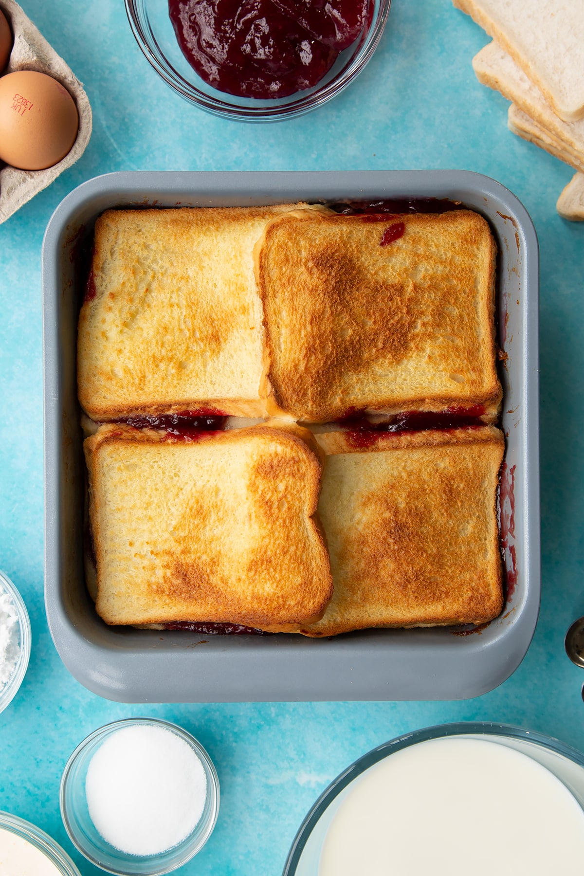 Overhead shot of the baking tin with the bread and butter pudding with jam having been in the oven.